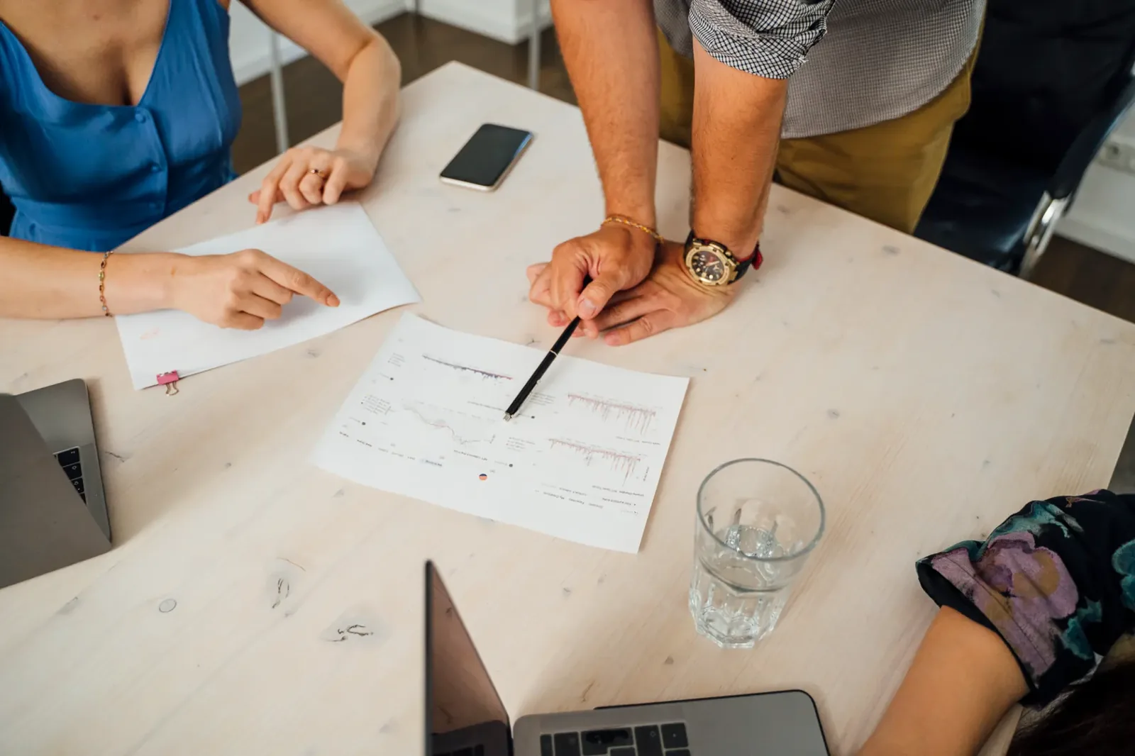 Berater und Kunde analysieren gemeinsam KI-Kennzahlen am Tisch